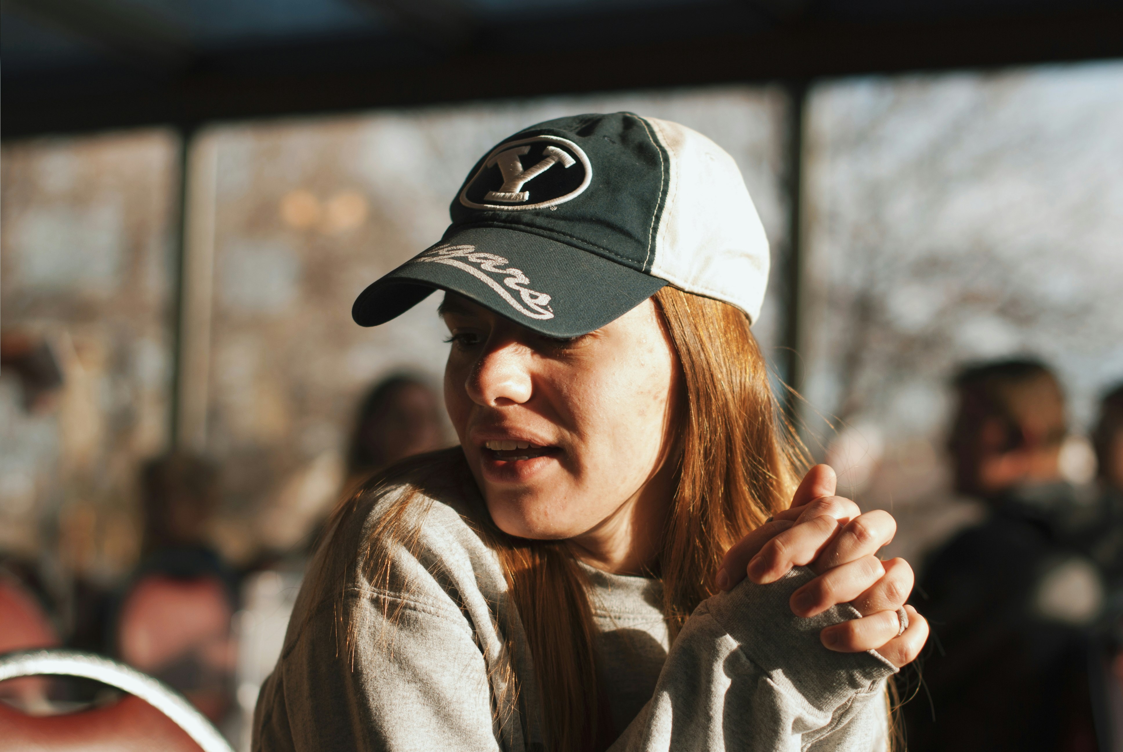 woman wearing grey sweater and cap looking side